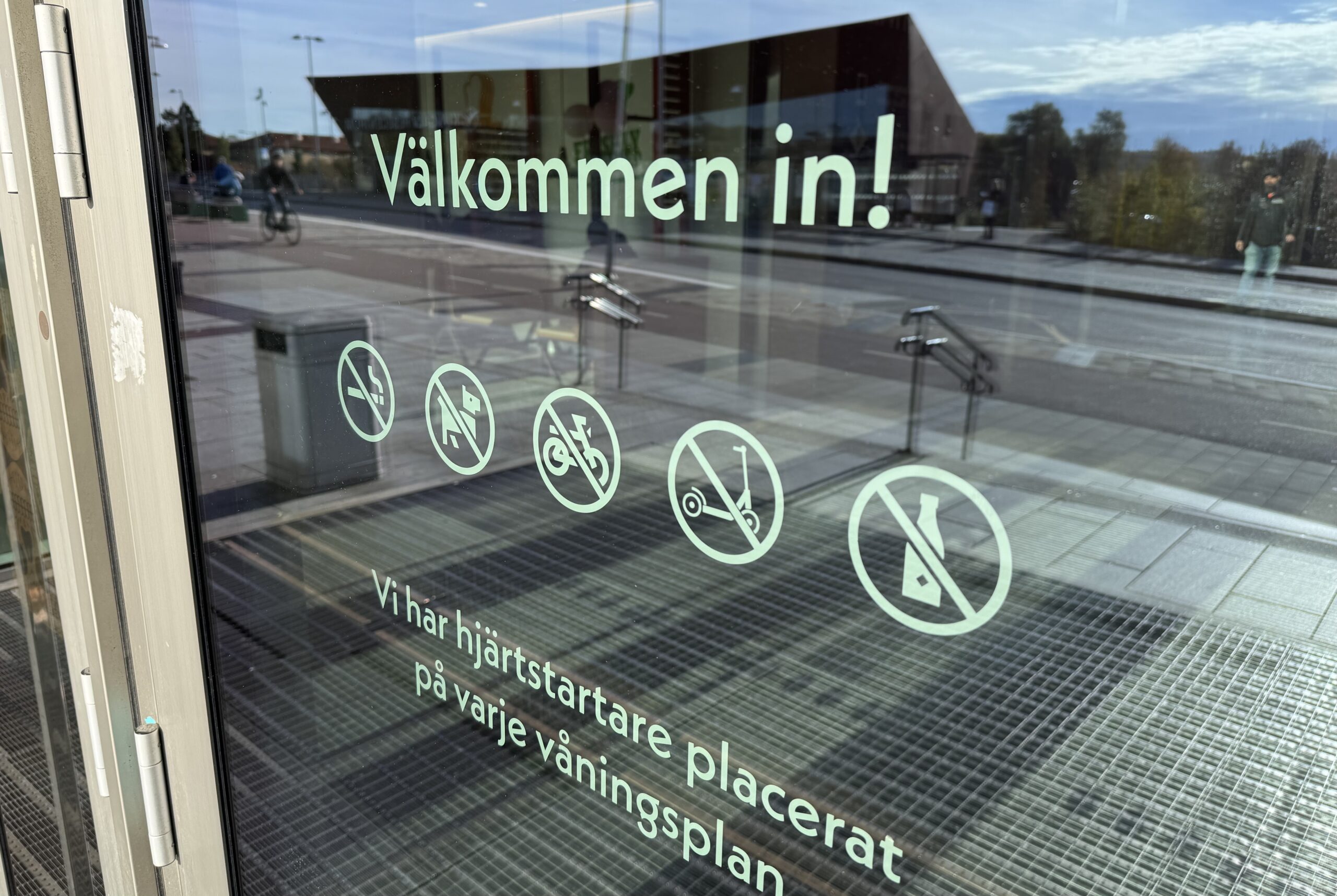 Bild på entrédörr med hänvisning att elsparkcykel ej får tas in i centret.