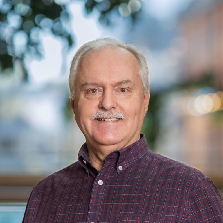 Man med grått hår och rutig skjorta